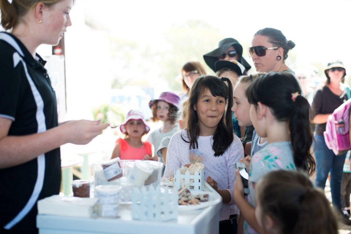 Black haired girl smilingly talking to her friend after tasting the gelato - 1280 × 854
